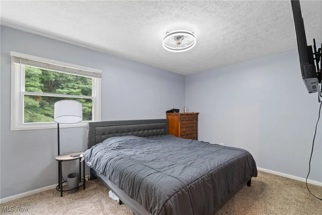 Bedroom featuring carpet floors and a textured ceiling
