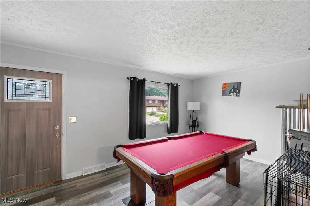 Playroom featuring wood finished floors, billiards table, and a textured ceiling