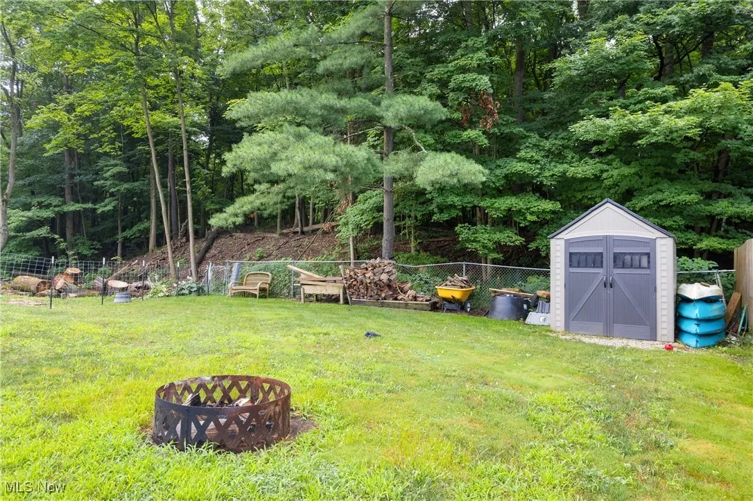 View of yard with a shed and a fire pit