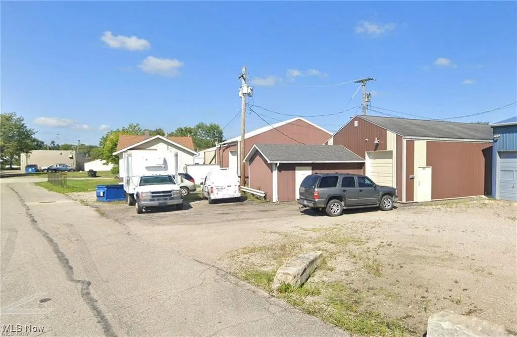 View of front facade featuring a garage and an outbuilding