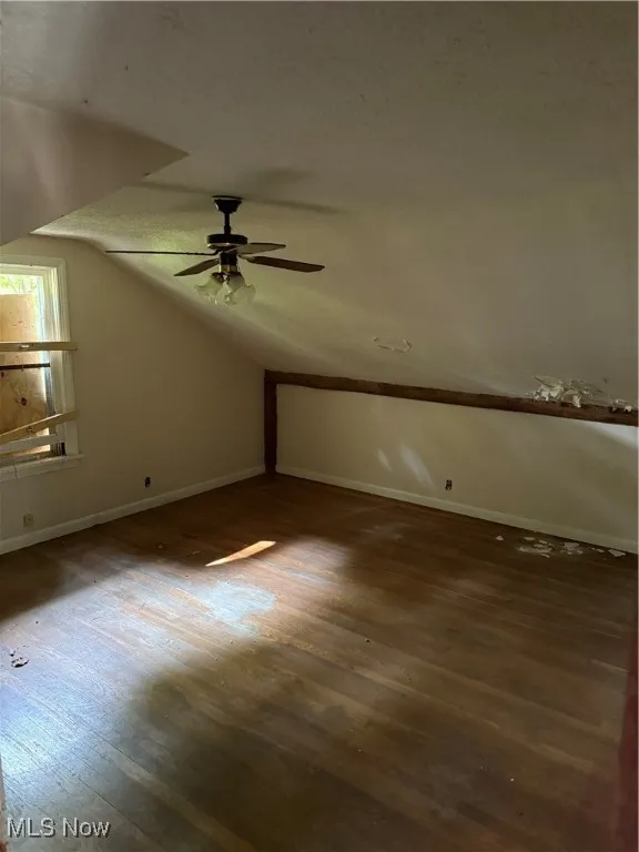 Additional living space featuring wood finished floors, vaulted ceiling, and ceiling fan