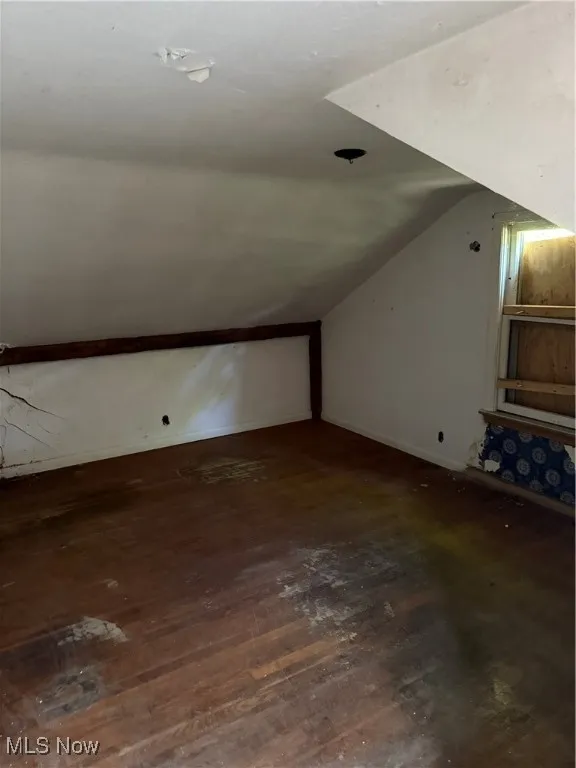 Additional living space with hardwood / wood-style flooring and lofted ceiling