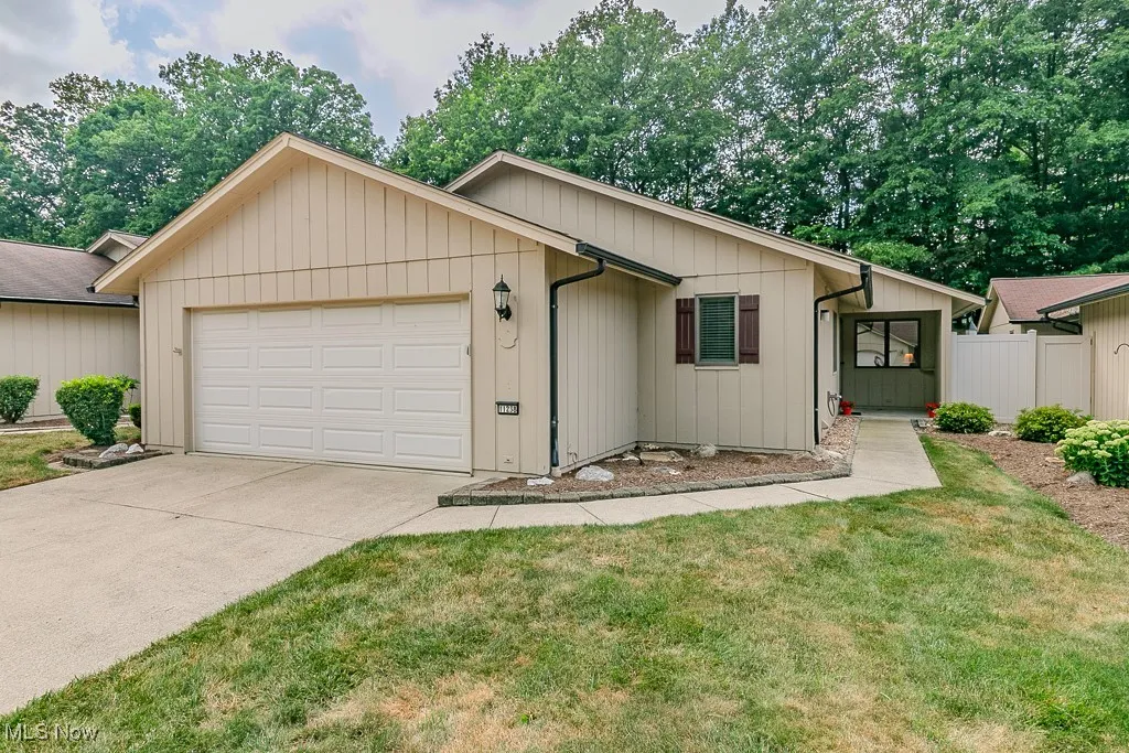 Ranch-style home featuring a garage and concrete driveway