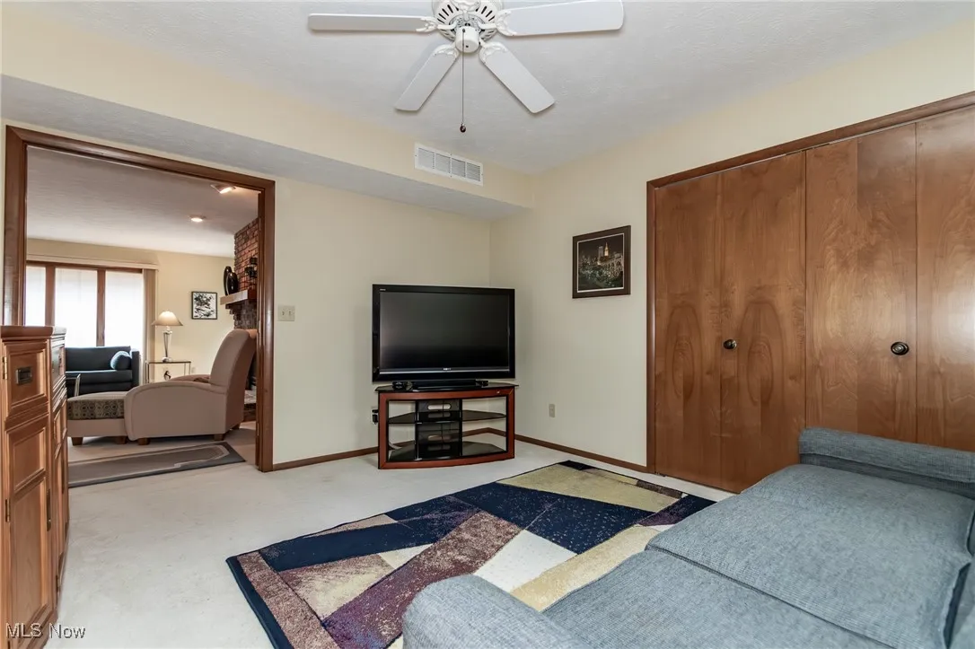 Bedroom with light carpet, a closet, and ceiling fan
