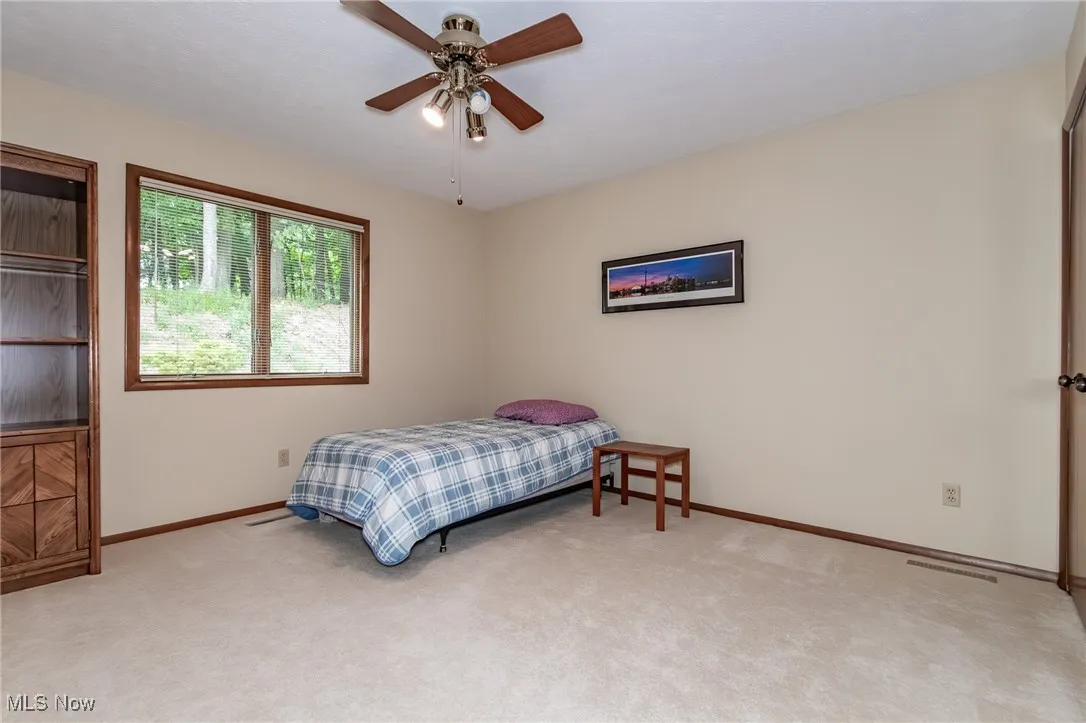 Bedroom featuring light colored carpet and a ceiling fan