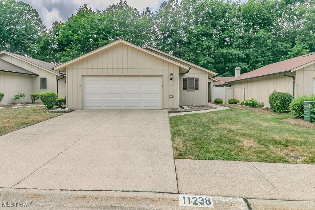 Ranch-style house with an attached garage, concrete driveway, and a front yard