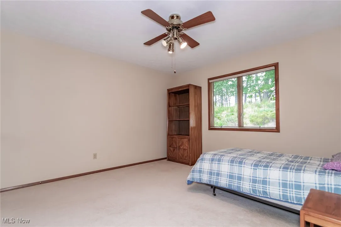 Bedroom with light colored carpet and ceiling fan