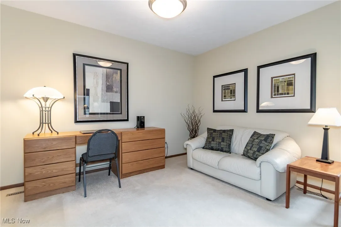 Home office with light carpet and baseboards