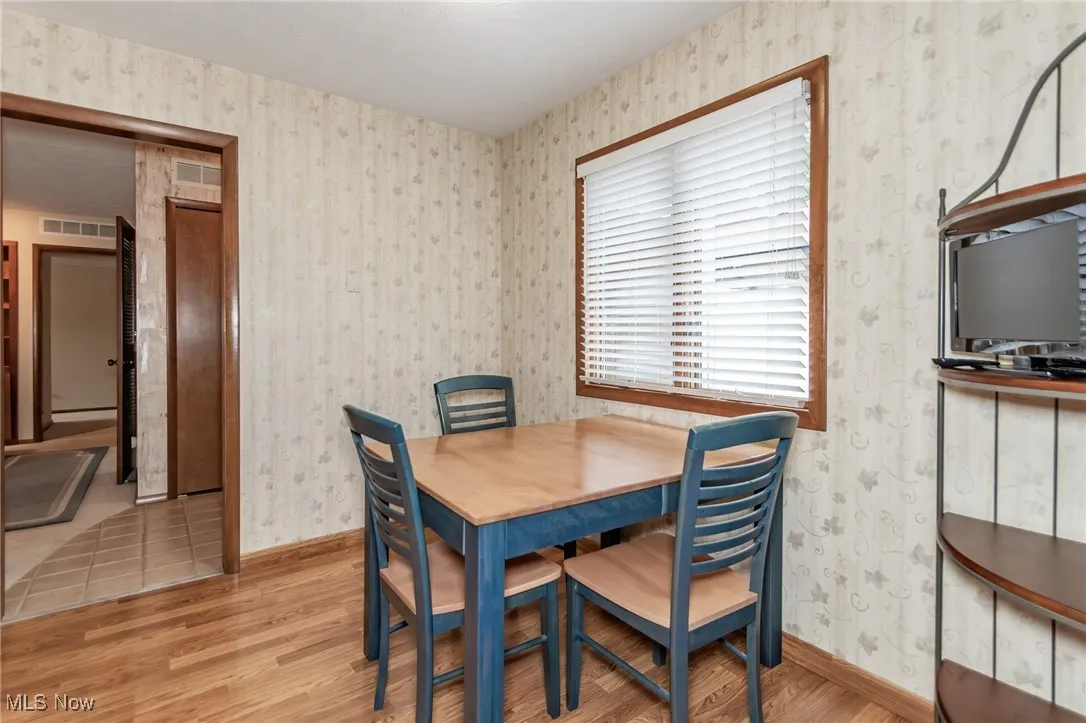 Dining space featuring wallpapered walls and light wood-style floors
