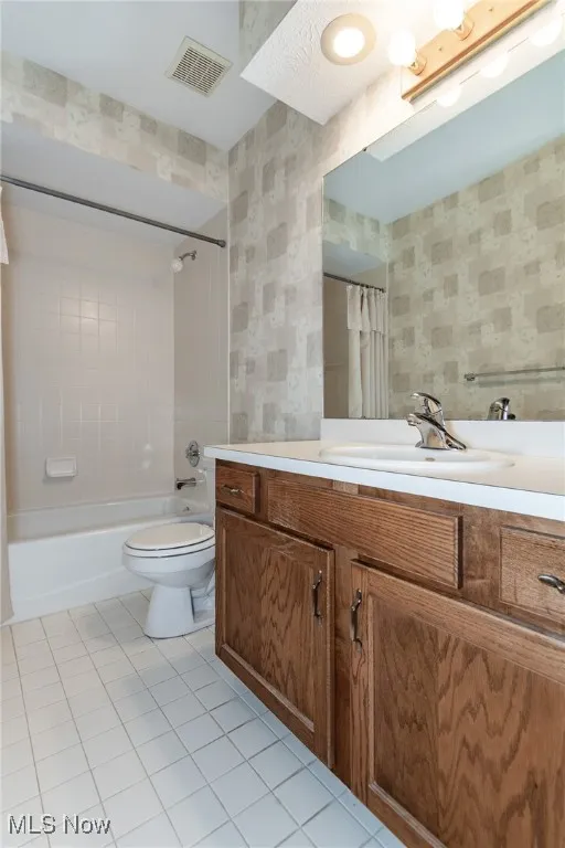 Bathroom featuring tile patterned floors, vanity, and shower / bathtub combination with curtain
