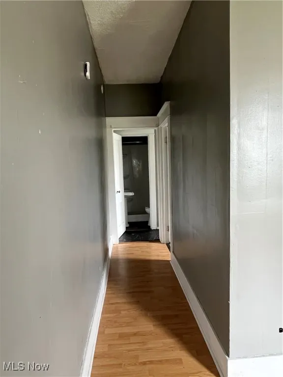 Hall featuring light wood-style flooring and baseboards
