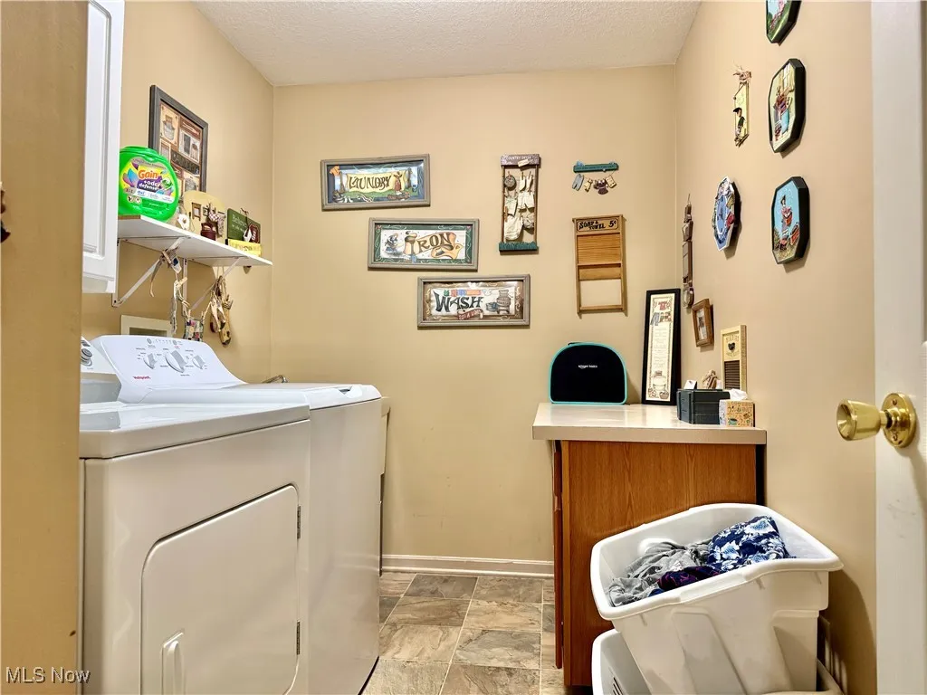 1st floor Laundry room featuring separate washer and dryer and cabinet space