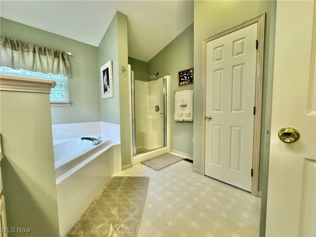 Bathroom featuring a stall shower and a bath