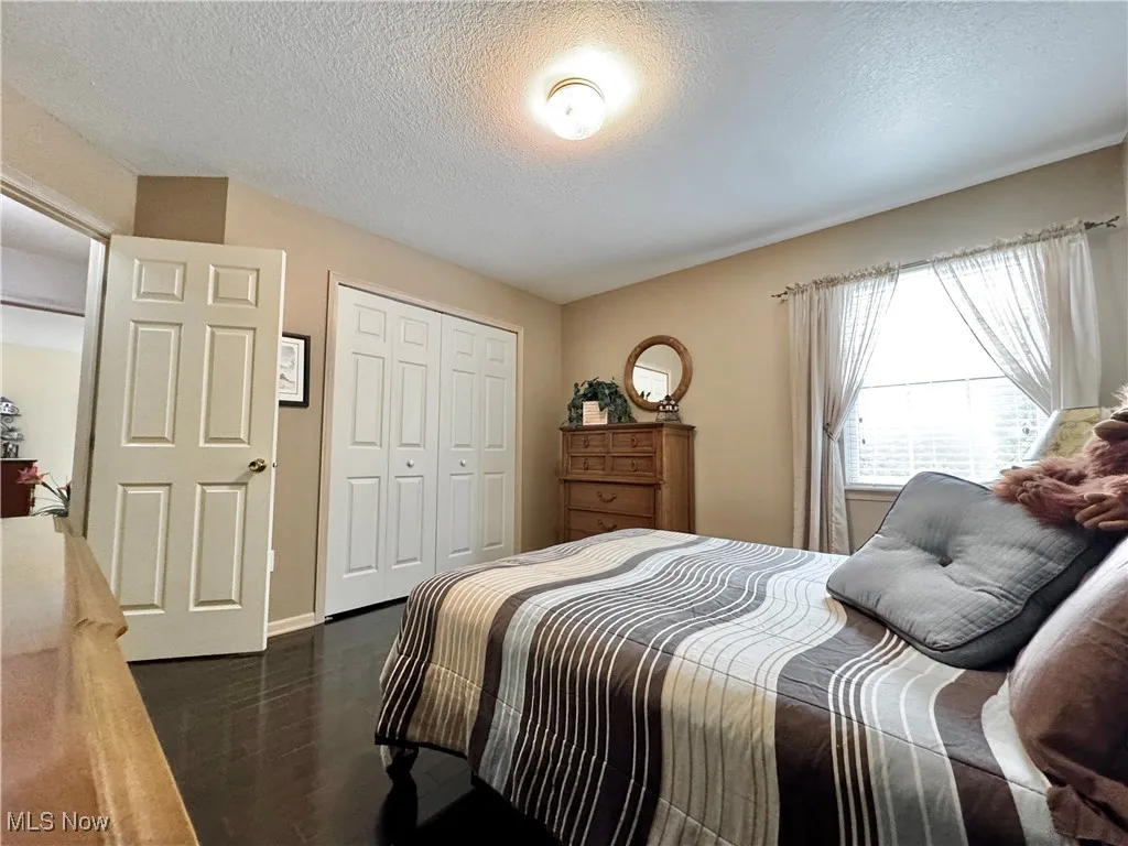 Bedroom featuring a textured ceiling and a closet