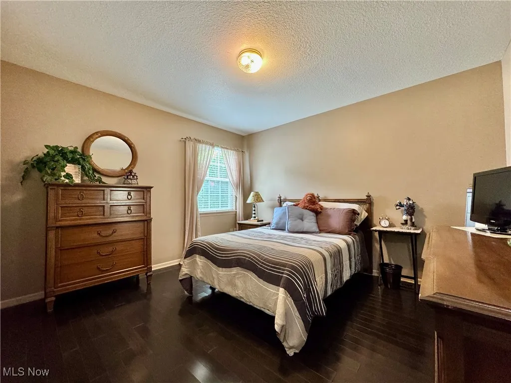 Bedroom featuring dark wood finished floors and a textured ceiling