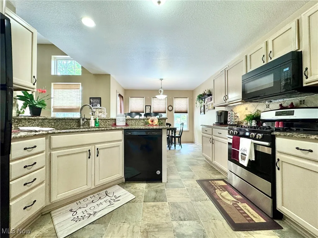 Kitchen featuring all appliances, plenty of recessed and natural light, granite countertops and tasteful backsplash