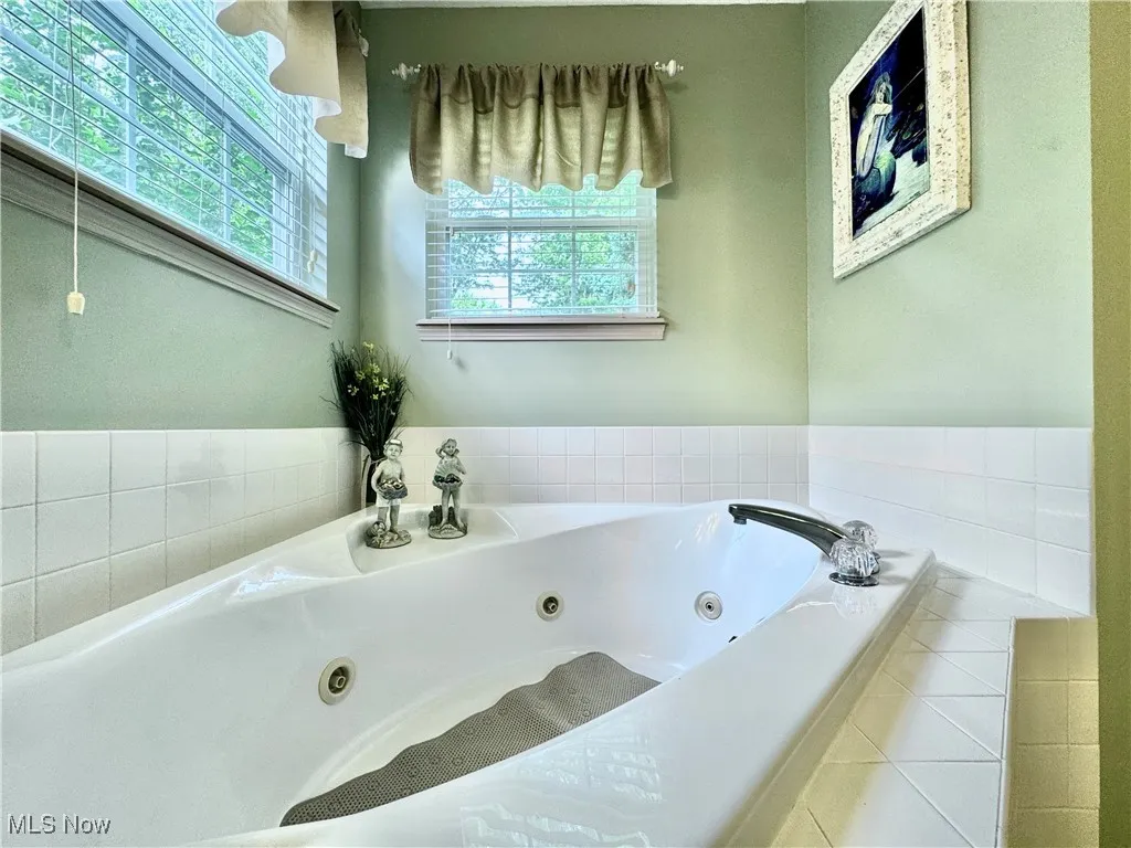 Bathroom featuring a tub with jets and tile patterned flooring