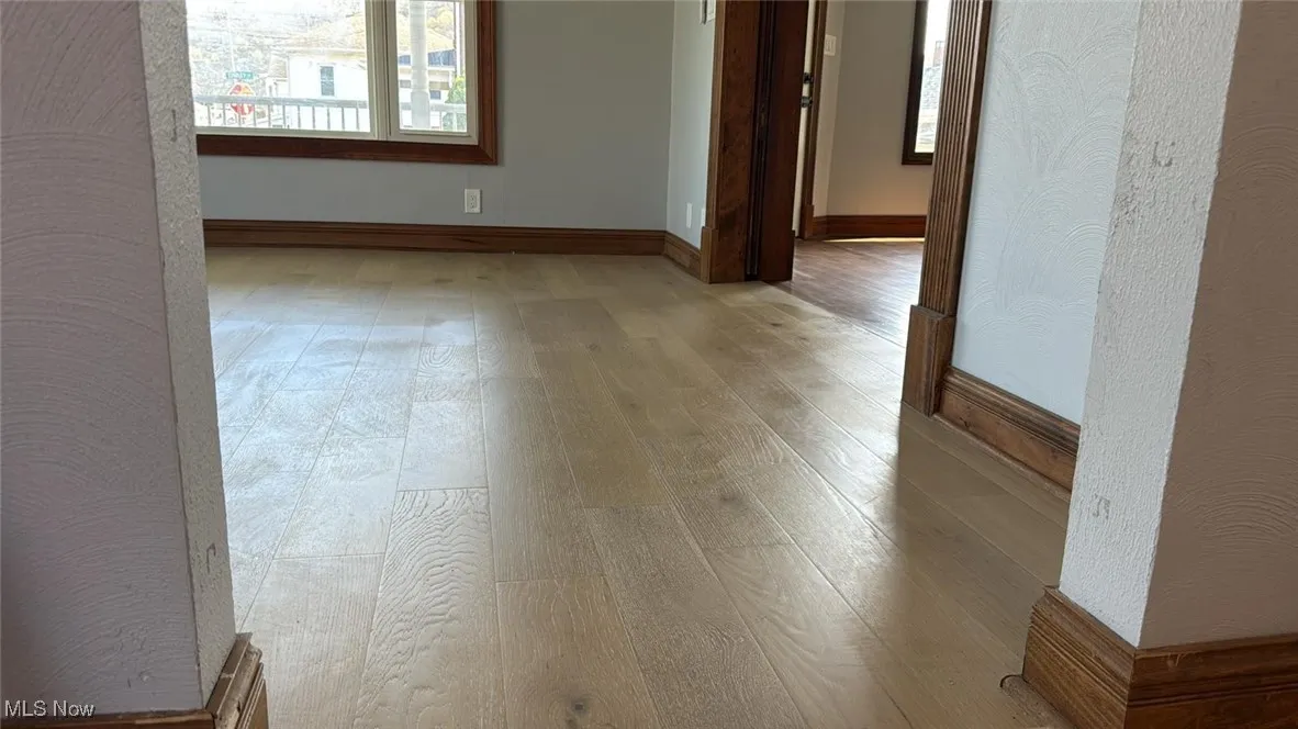 Spare room featuring baseboards and wood finished floors