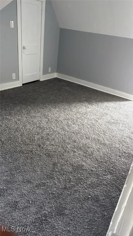 Bonus room featuring lofted ceiling and carpet