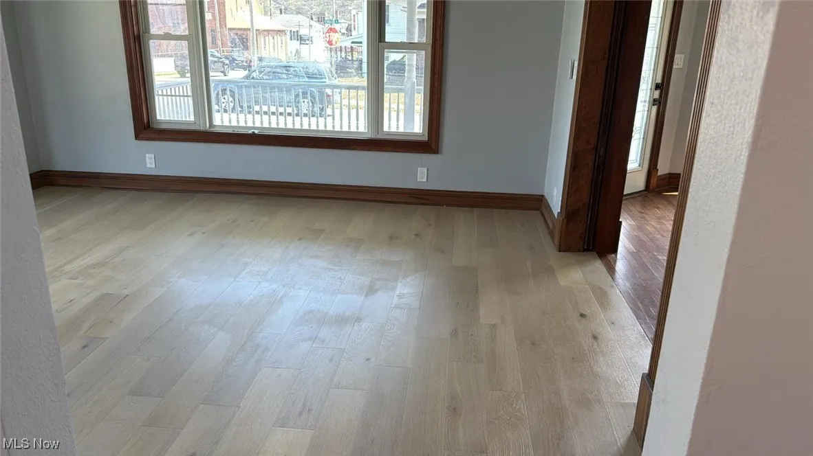 Unfurnished room featuring light wood-type flooring and baseboards