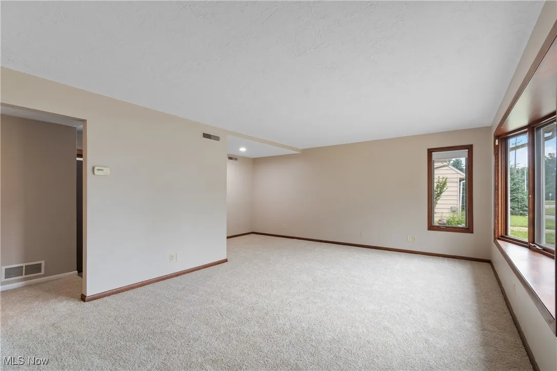 Spare room featuring light carpet, a textured ceiling, and recessed lighting