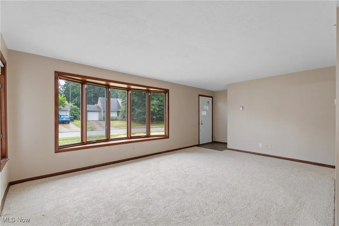 Carpeted empty room featuring baseboards