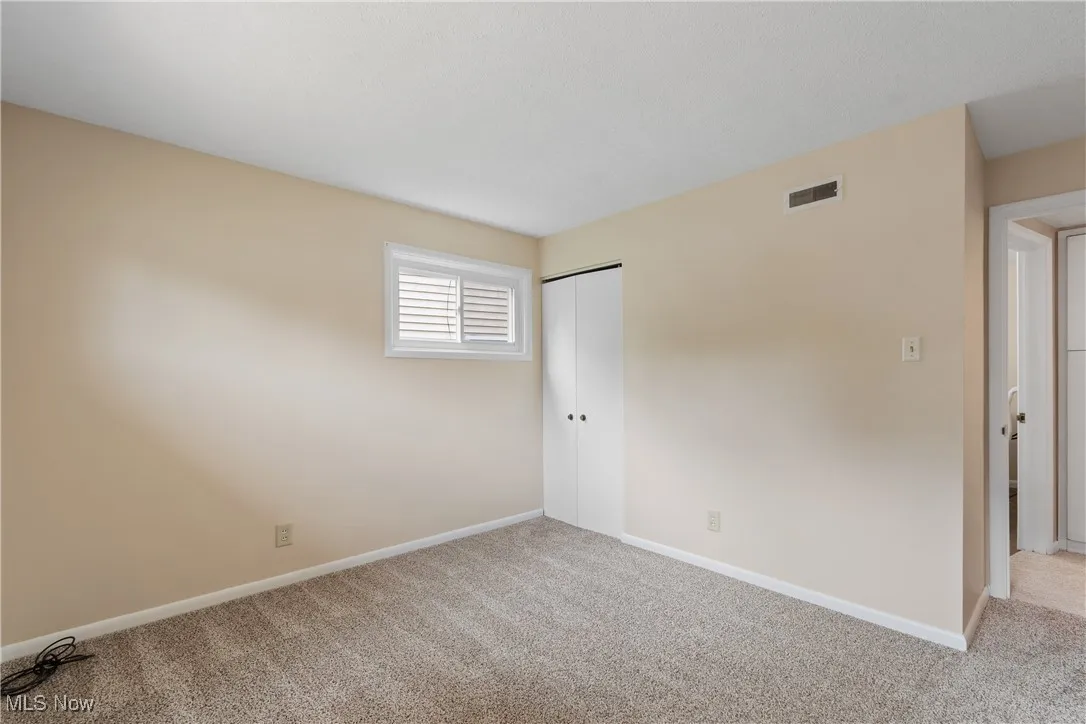 Carpeted empty room featuring baseboards
