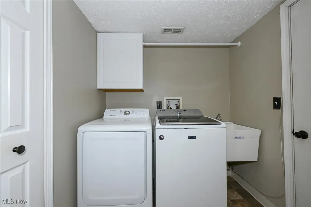 The laundry room has vinyl flooring and a closet currently used as a pantry for the kitchen. The washer and dryer stay