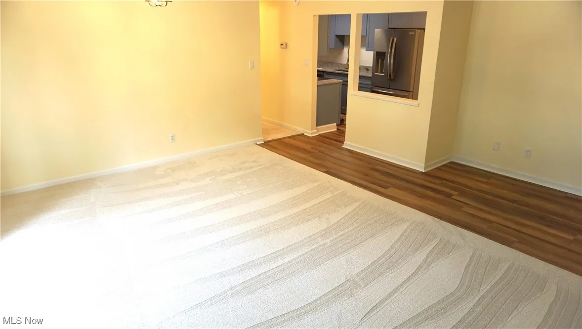 Unfurnished room with dark wood-style flooring and baseboards