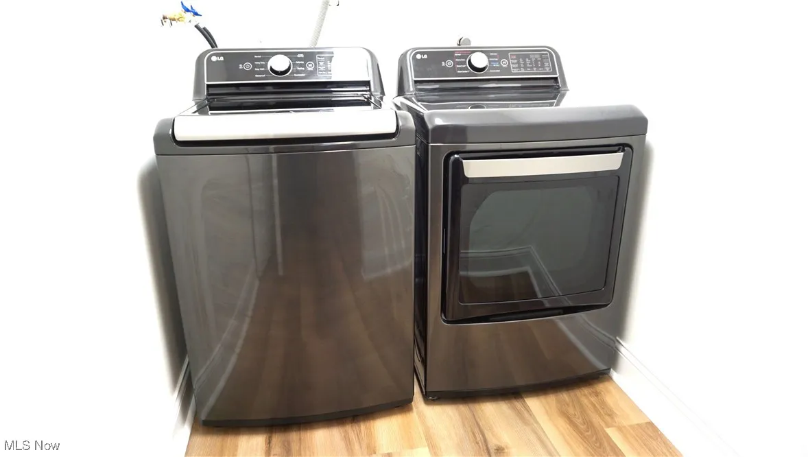 Laundry area featuring washer and clothes dryer and light wood-type flooring