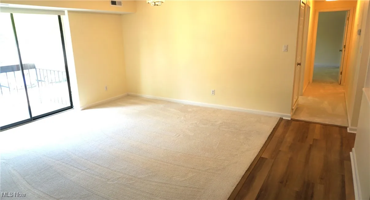 Unfurnished room with plenty of natural light, light colored carpet, and light wood-style floors