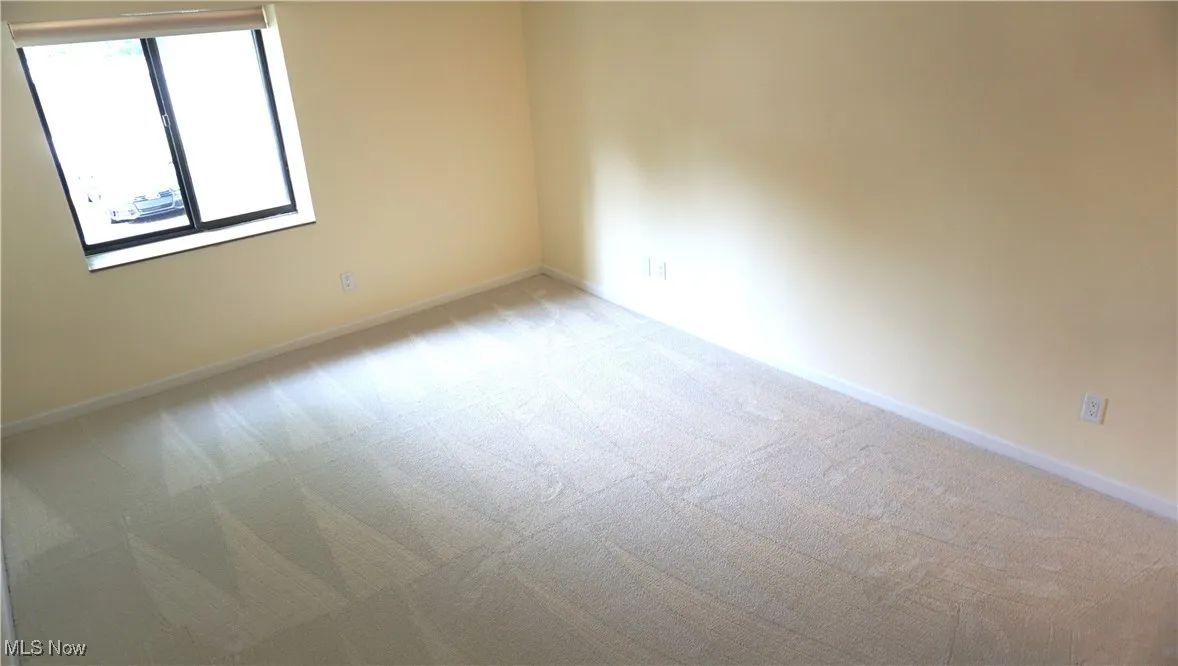 Empty room featuring light carpet and baseboards