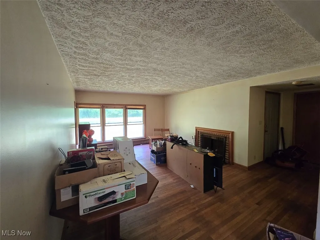 Living room with a textured ceiling and wood finished floors