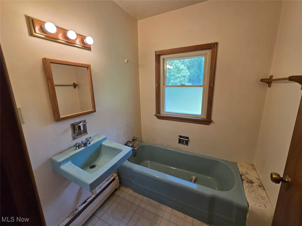 Full bathroom with a bathtub and a sink