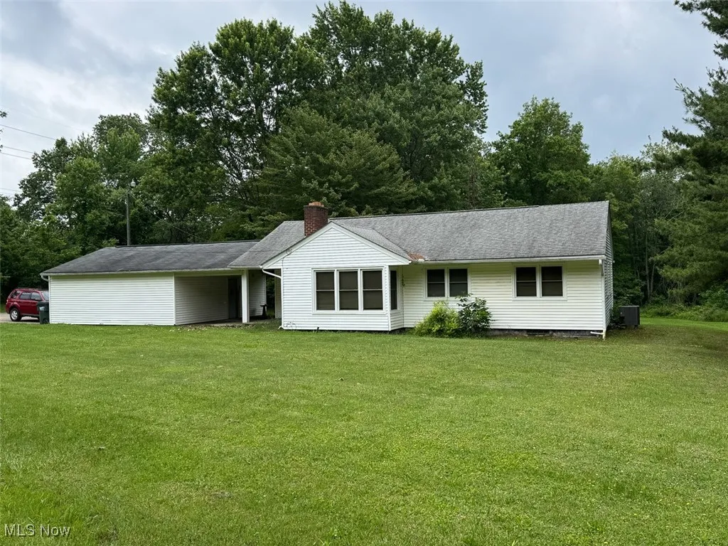 Ranch-style home featuring a front lawn and a chimney
