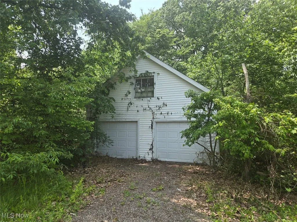 View of side of home with a detached garage