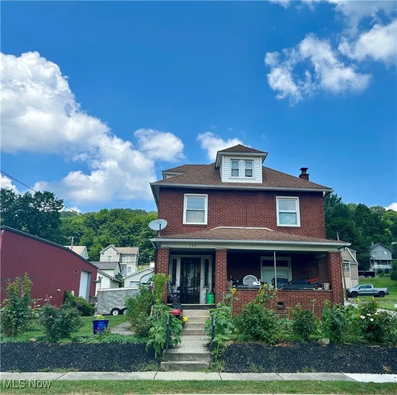 Traditional style home with covered porch and brick siding