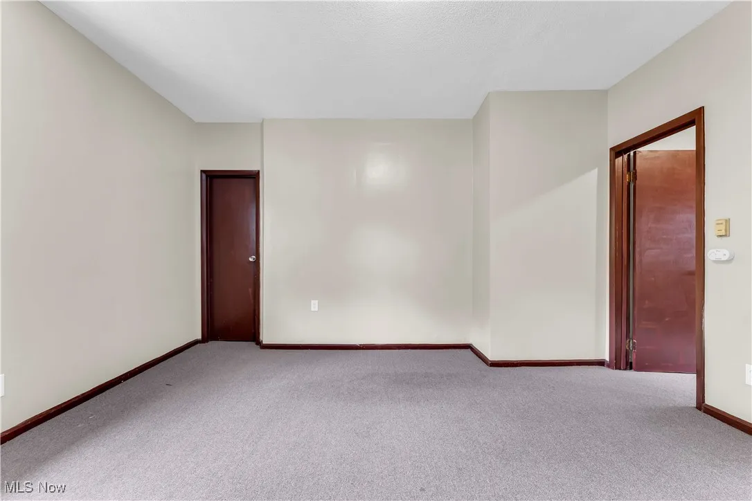 Carpeted empty room featuring baseboards