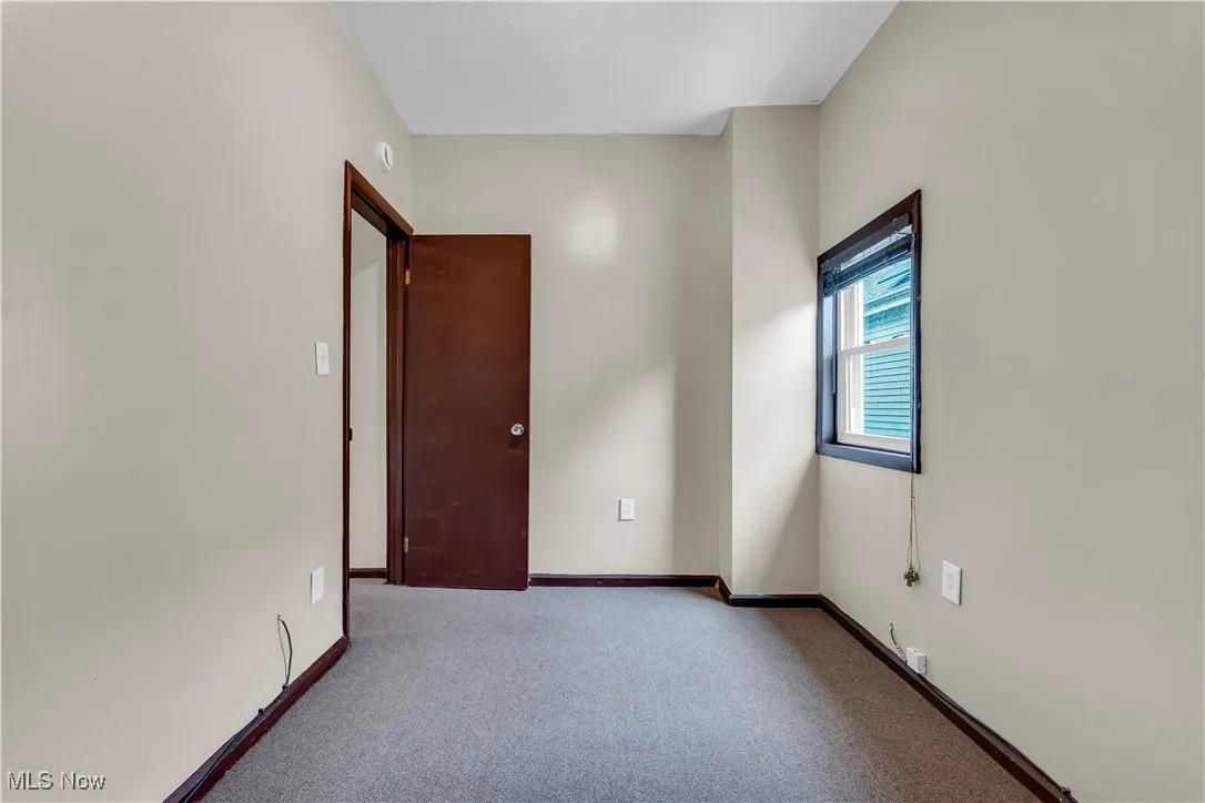 Carpeted empty room featuring baseboards