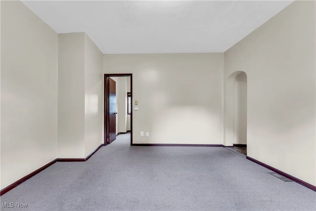 Unfurnished room featuring carpet flooring and arched walkways