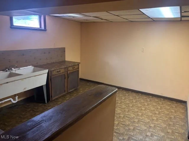 Bar with baseboards and a drop ceiling