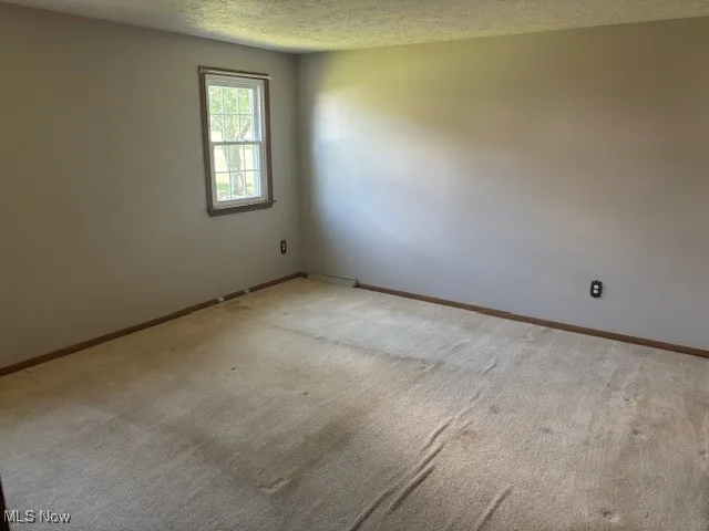 Spare room with carpet flooring and a textured ceiling
