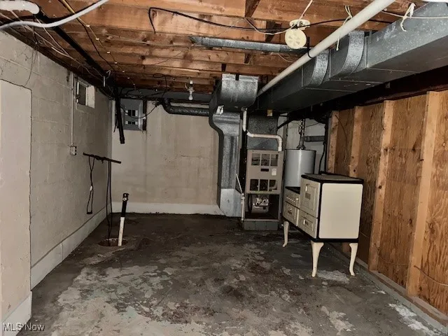 Unfinished below grade area with heating unit and water heater