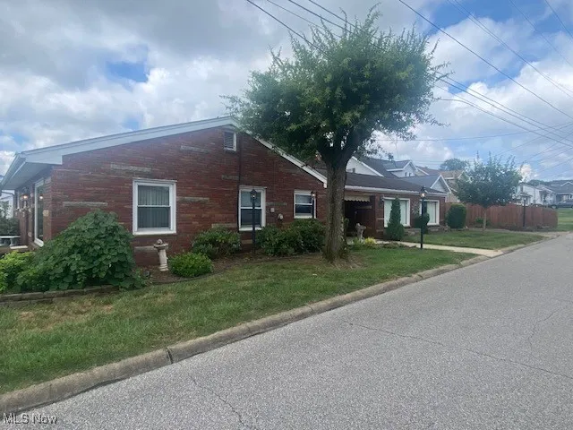 View of front of home with brick siding and a front yard