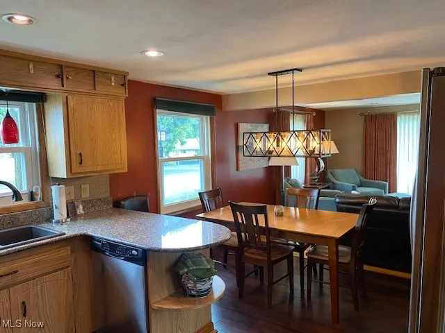 Kitchen featuring dishwasher, dark wood-type flooring, recessed lighting, pendant lighting, and open shelves