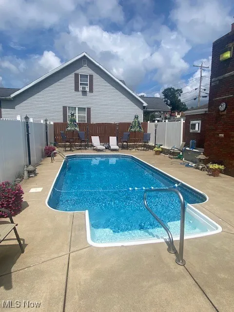 View of swimming pool featuring a patio and a fenced backyard