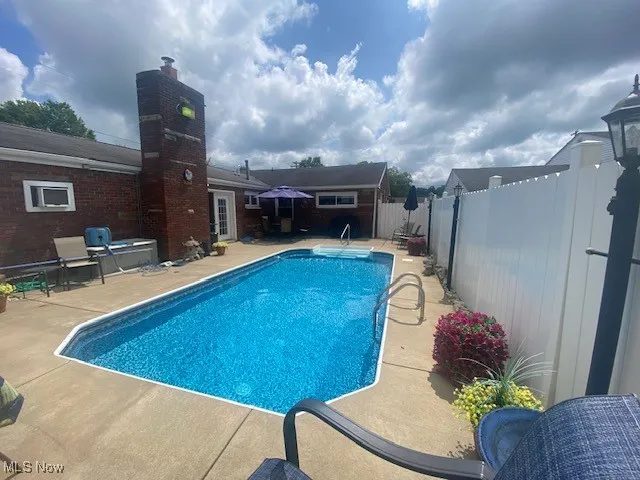 View of pool with a patio and a fenced backyard