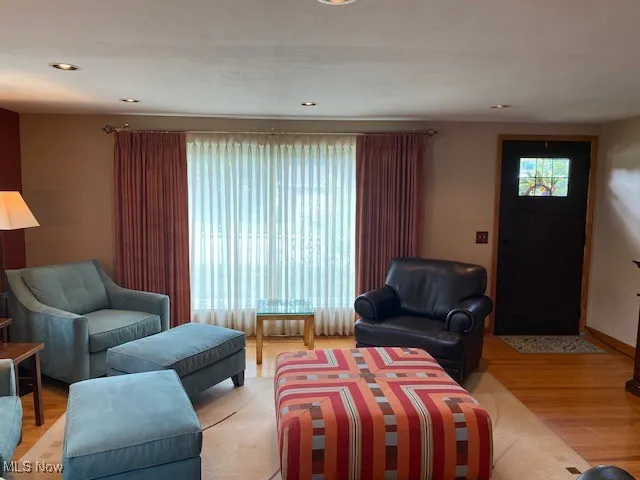 Living area with healthy amount of natural light, light wood finished floors, and recessed lighting