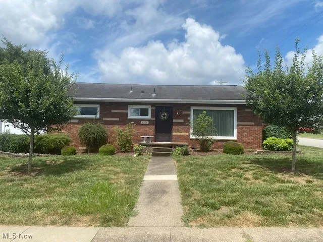 Ranch-style house with brick siding and a front yard