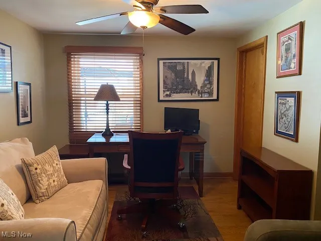 Office space with wood finished floors and a ceiling fan